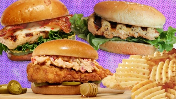 Три курячі бургери та купа вафельної картоплі фрі з Chick-fil-A на фіолетовому фоні.