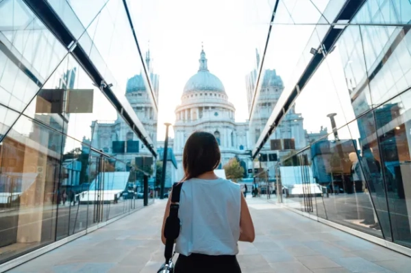 Задній вид молодої азійської жінки, що йде проти міського пейзажу Лондона