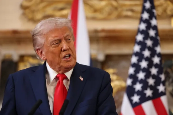 Дональд Трамп посміхається праворуч перед прапорами США та Великої Британії