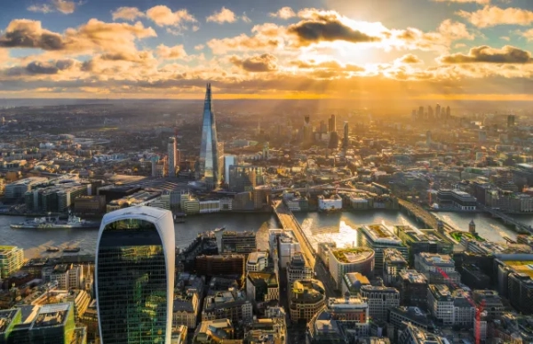 Вид з висоти пташиного польоту на горизонт центрального Лондона на заході сонця. Золоте сонце пробивається крізь хмари.