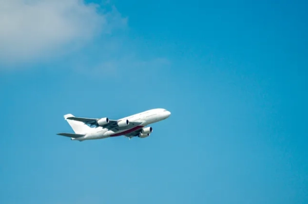 Літак летить крізь яскраве блакитне небо.