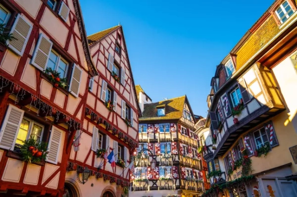 Різдвяні прикраси на старих, барвистих будинках у Страсбурзі, Франція, яскравого зимового дня.