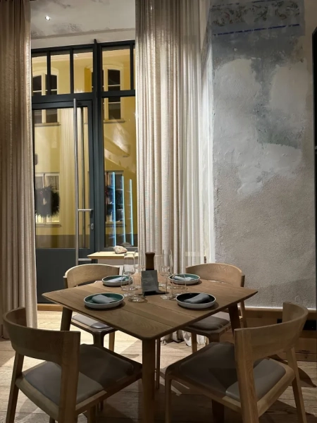 Сервірований стіл на чотирьох з вікном на задньому плані