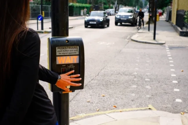 Пішохід чекає на сигнал світлофора, щоб перейти вулицю