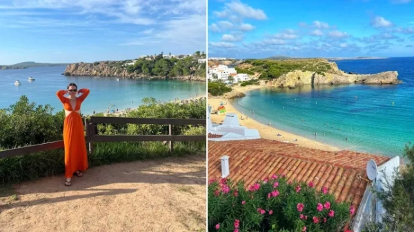 Софі Мей Вільямс стоїть на оглядовому майданчику на Менорці біля моря, а також вид на Середземне море на Менорці з рожевими квітами на передньому плані.